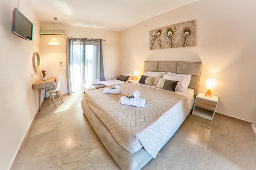 een slaapkamer met een groot bed en 2 handdoeken bij Costas apartments in Mesongi