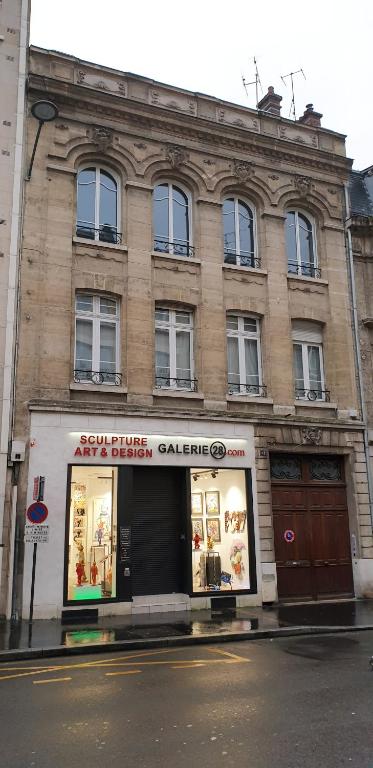 un magasin dans une rue en face d'un immeuble dans l'établissement REIMS-ESCAPADE Gallery, à Reims