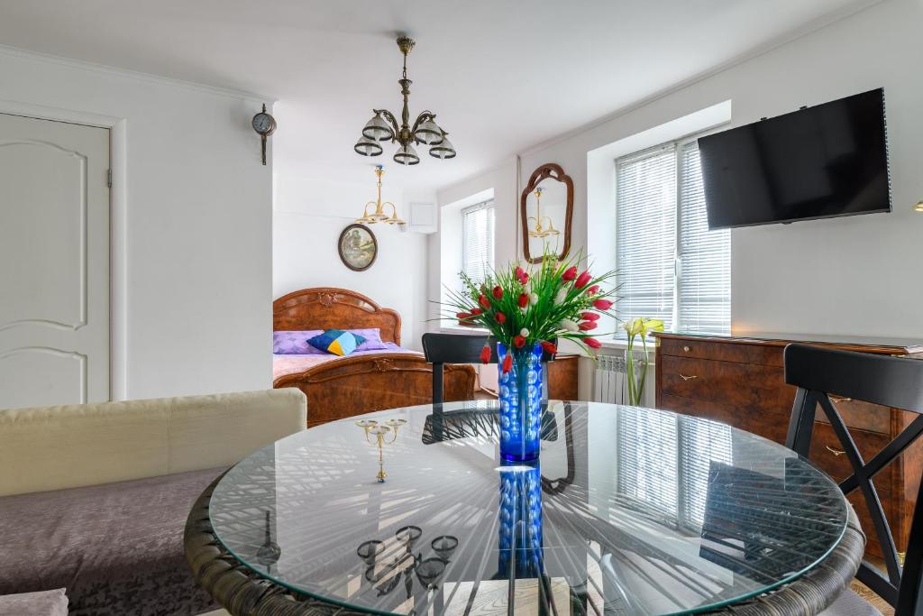 una sala de estar con una mesa de cristal con flores. en RentalSPb Altayskaya Apartments en San Petersburgo