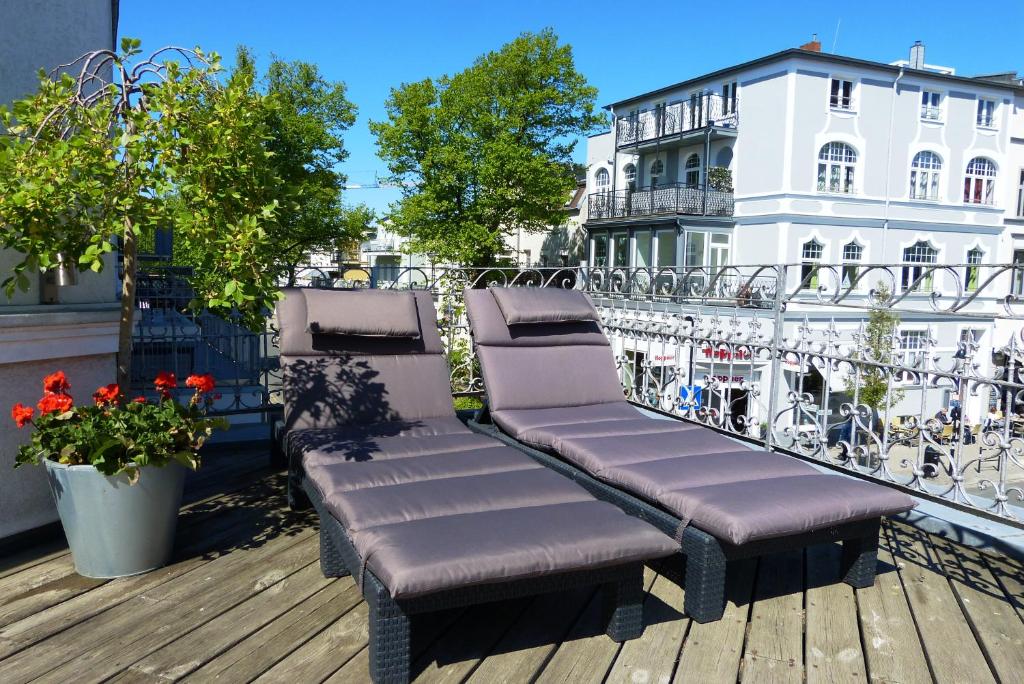 ein Paar Bänke auf dem Balkon in der Unterkunft Residenzen am Kirchenplatz in Warnemünde