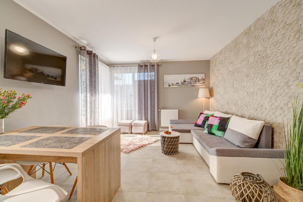 a living room with a couch and a table at Nadmorski Szept in Dziwnówek