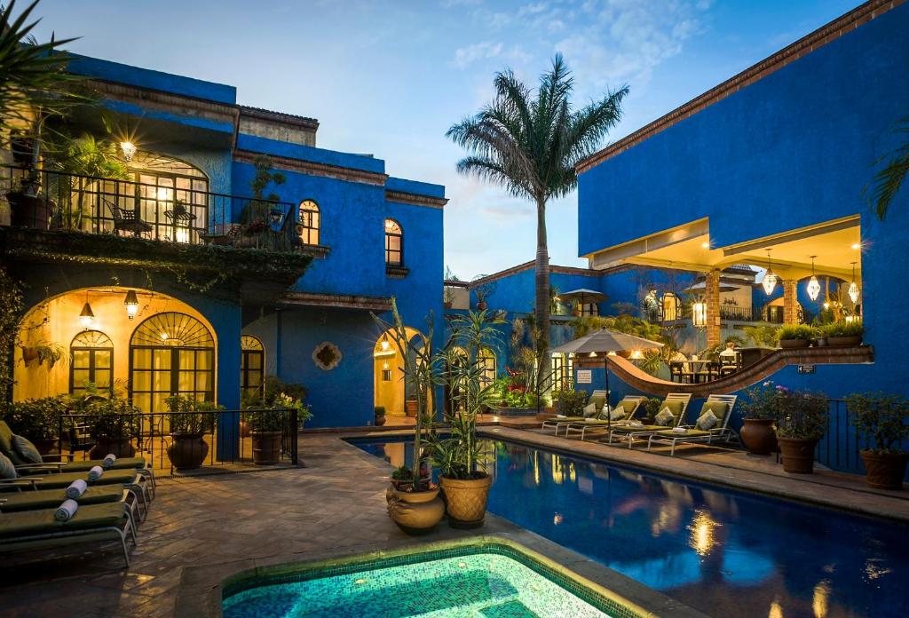 a blue house with a swimming pool in front of it at La Villa del Ensueno Boutique Hotel in Guadalajara