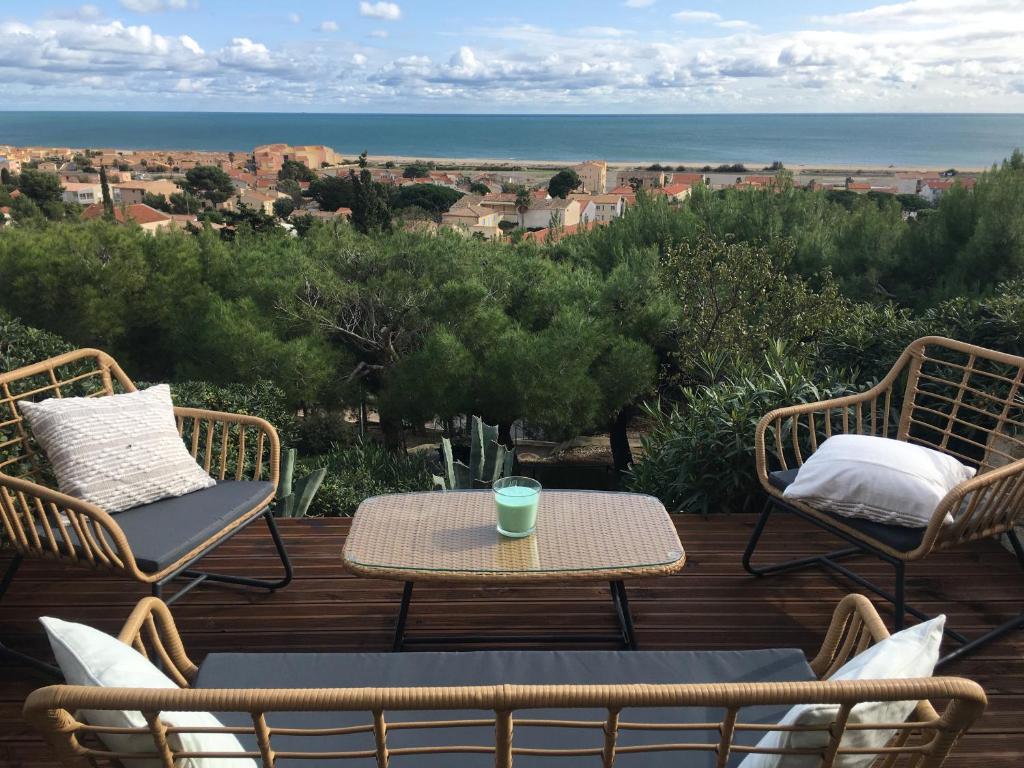 - une table et des chaises sur une terrasse avec vue sur l'océan dans l'établissement Saint-Pierre-la-Mer, à Fleury