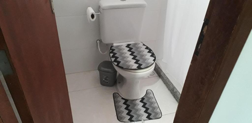 uma casa de banho com um WC com uma capa a preto e branco em Fort em Angra dos Reis