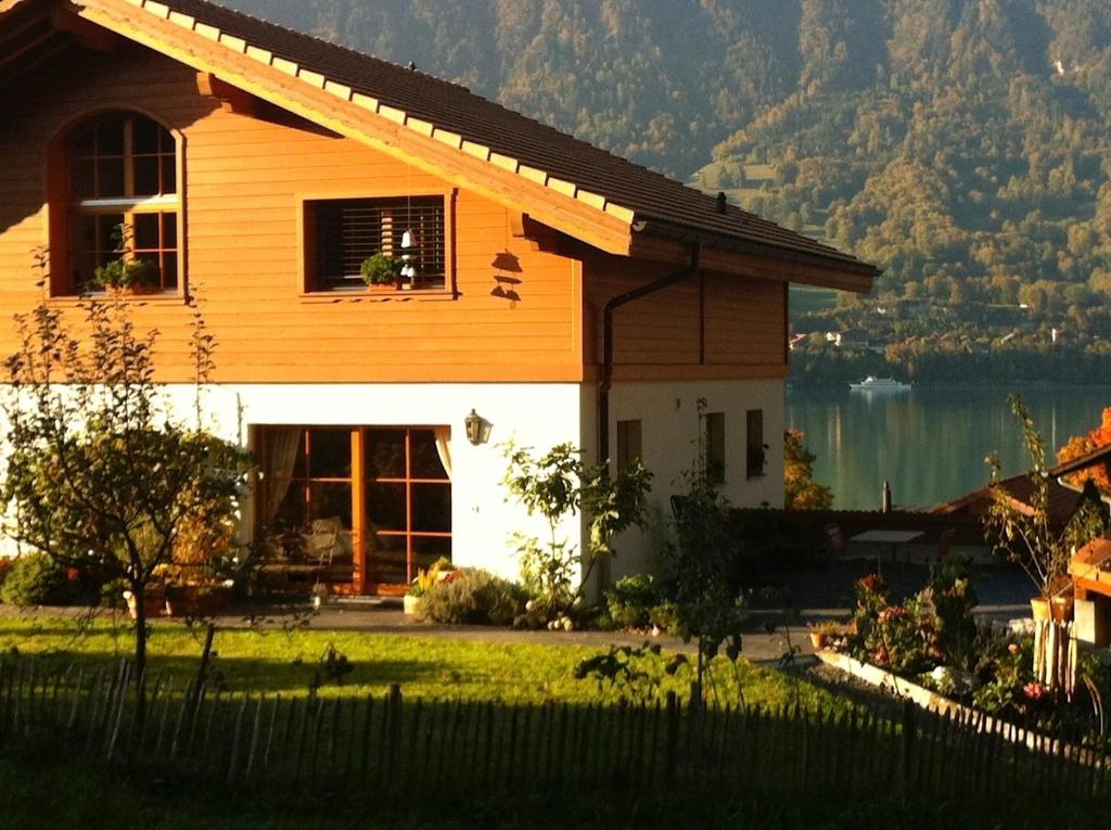 ein Haus mit See und Bergen im Hintergrund in der Unterkunft Sam & Cindy Mühlemann in Interlaken