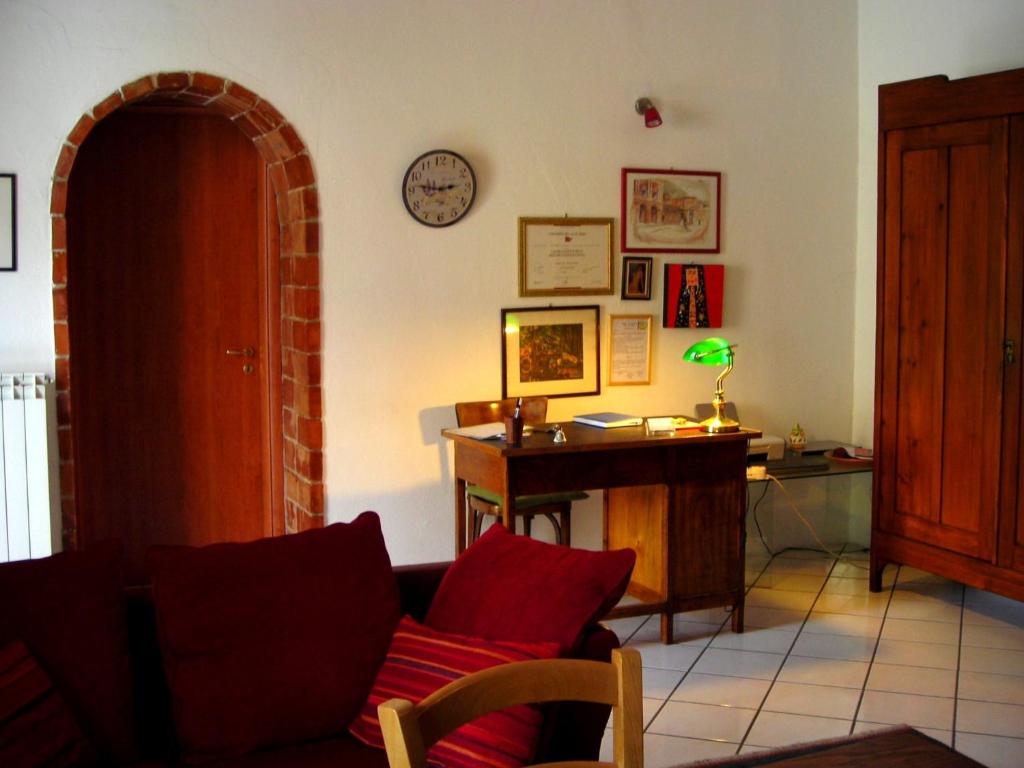 a living room with a couch and a desk and a clock at B&B Ixia in Carolei