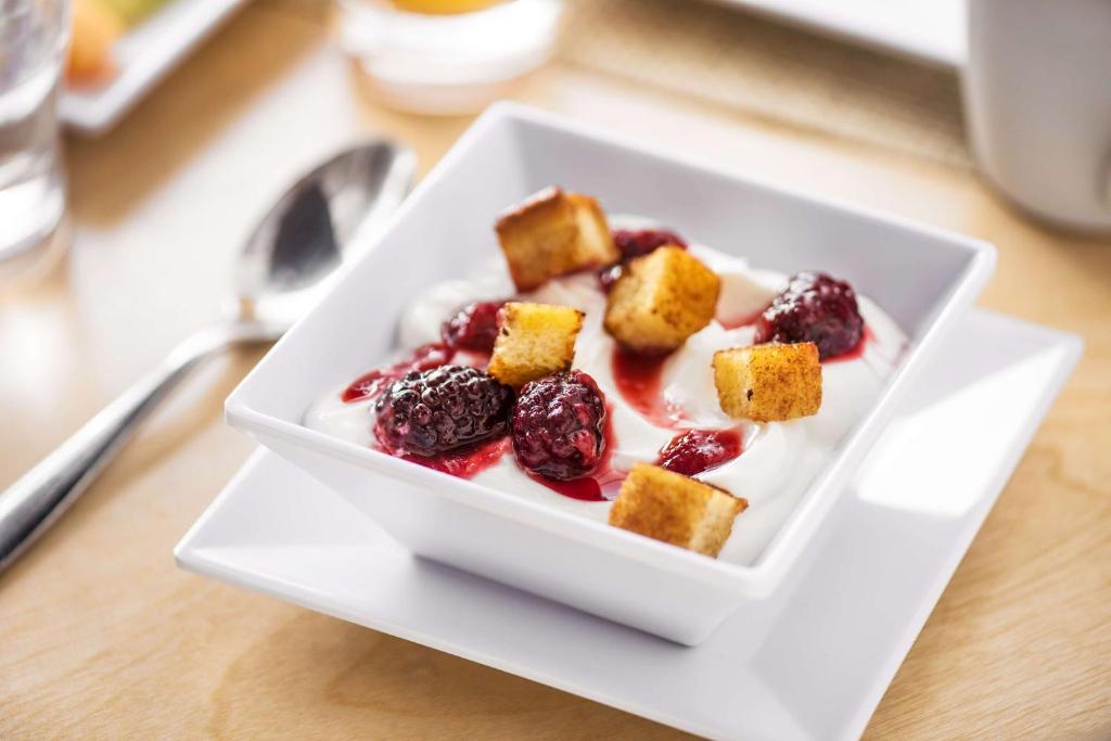 a white bowl of food with berries and whipped cream at Hyatt House Anchorage in Anchorage