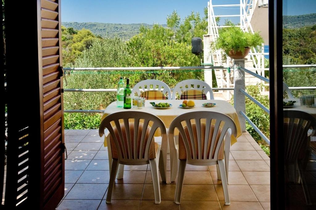 una mesa y sillas en un balcón con vistas en Apartment Goran - close to the sea, en Nečujam
