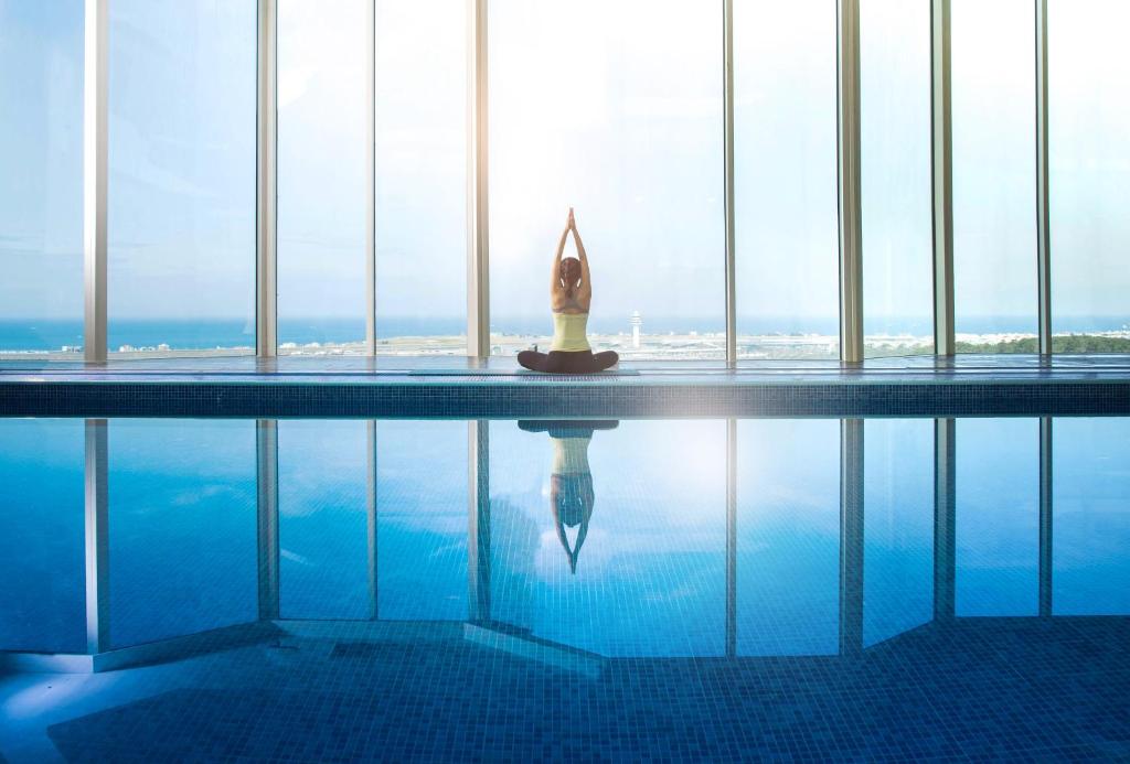 a swimming pool in a building with a view of the ocean at Hotel Sirius in Jeju