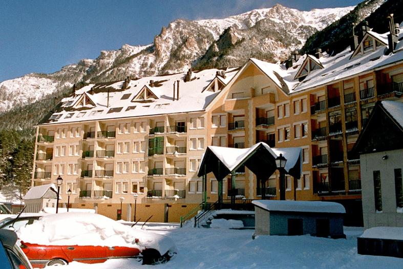 un gran edificio con nieve en el techo frente a él en Altur 5 Canfranc Estación, en Canfranc-Estación