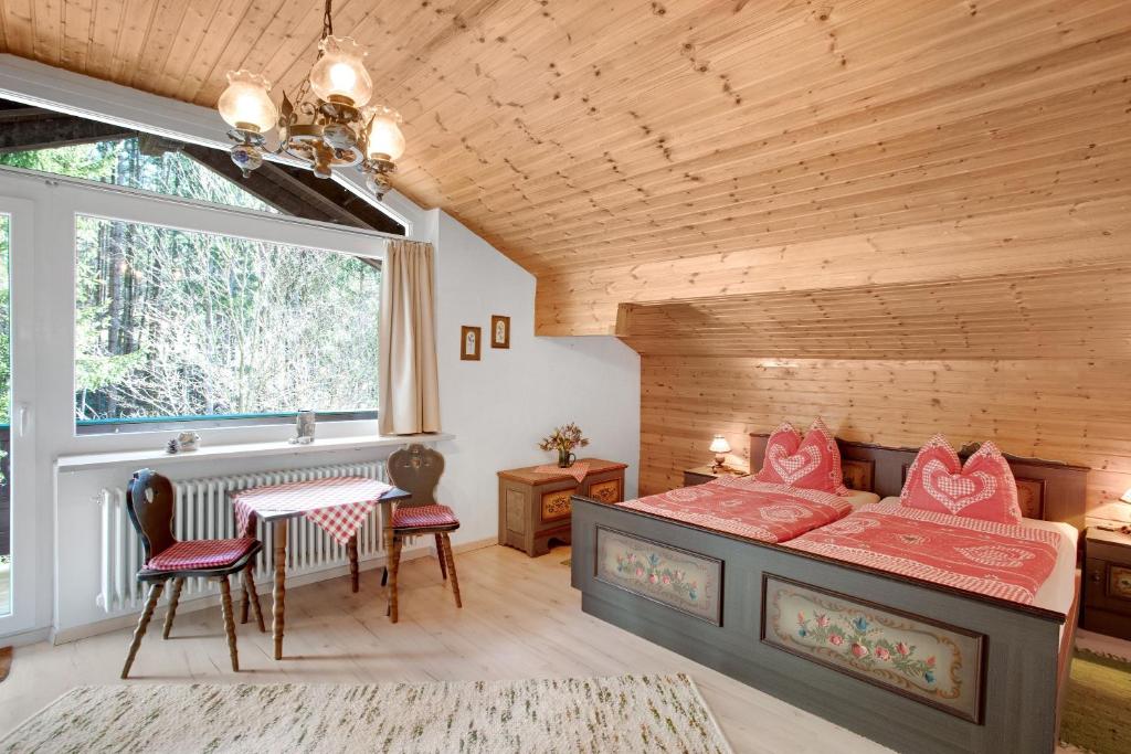 a bedroom with a bed and a table and a window at Ferienwohnung Haus Reiteralm in Schneizlreuth