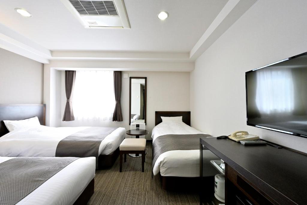 Postel nebo postele na pokoji v ubytování Saijo Urban Hotel