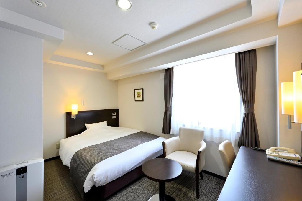 Postel nebo postele na pokoji v ubytování Saijo Urban Hotel