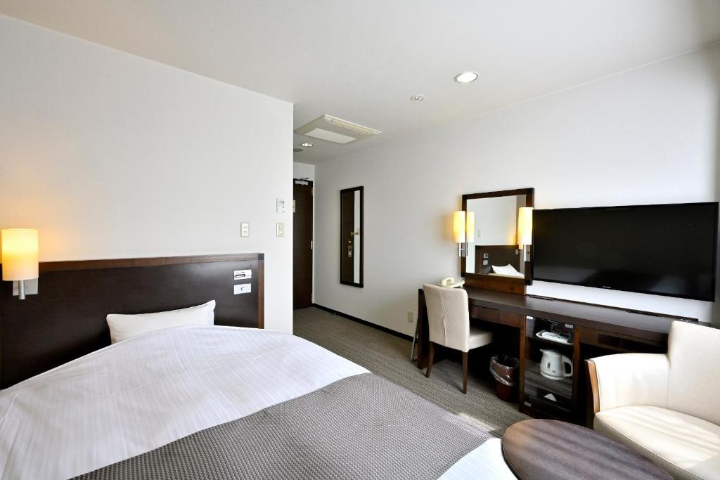 Postel nebo postele na pokoji v ubytování Saijo Urban Hotel