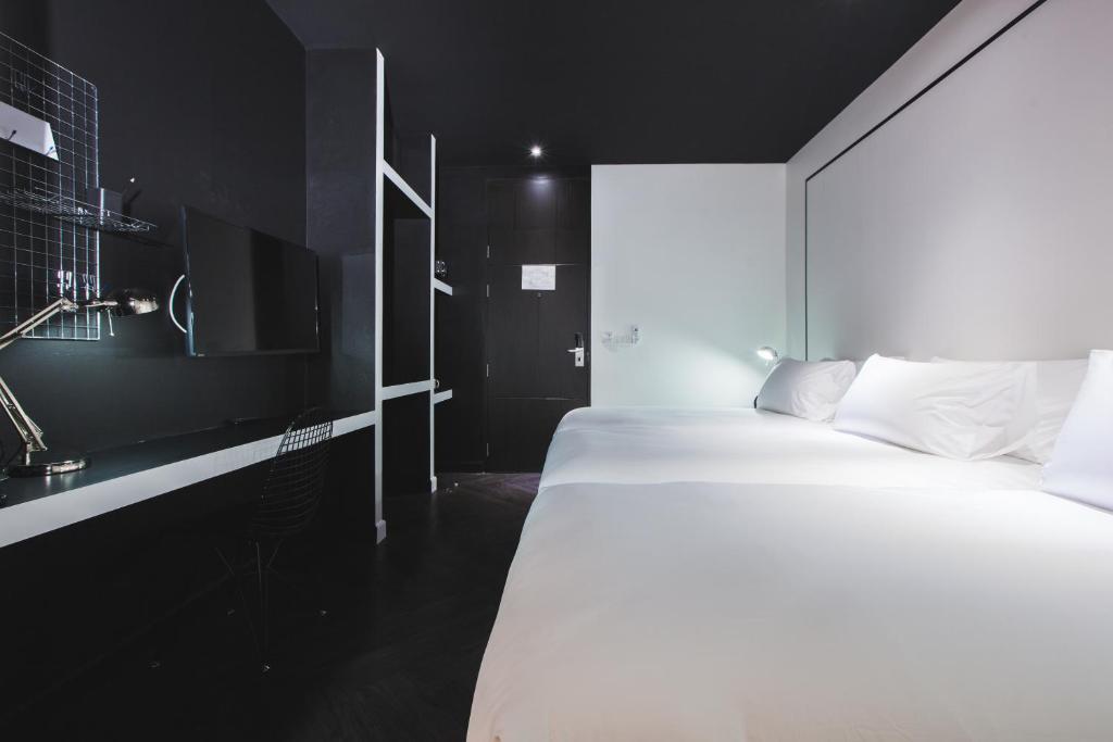 a bedroom with a large white bed and a sink at Blu Monkey Hub and Hotel Phuket Town- Free All Day Coworking space in Phuket Town