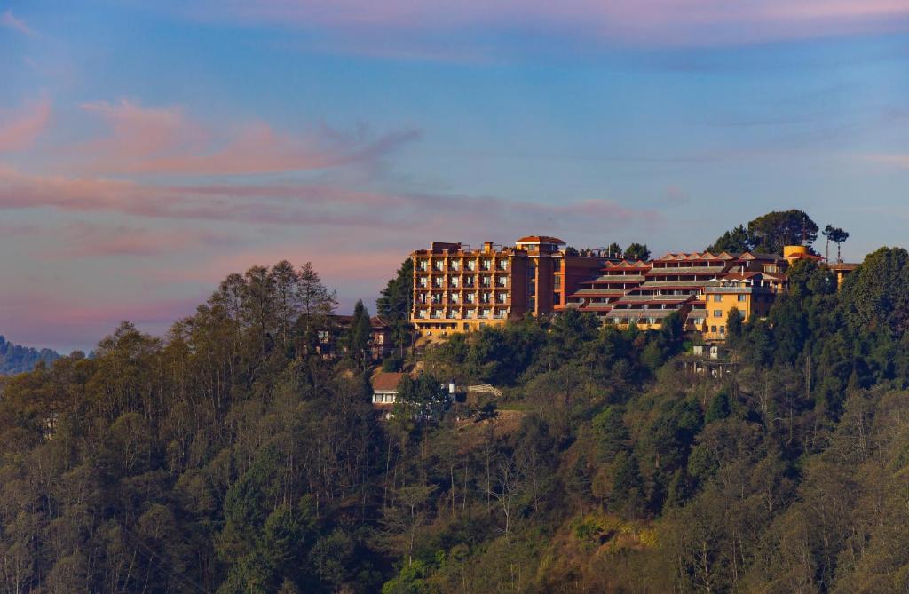 ein Gebäude auf einem Hügel mit Bäumen in der Unterkunft Club Himalaya, by ACE Hotels in Nagarkot