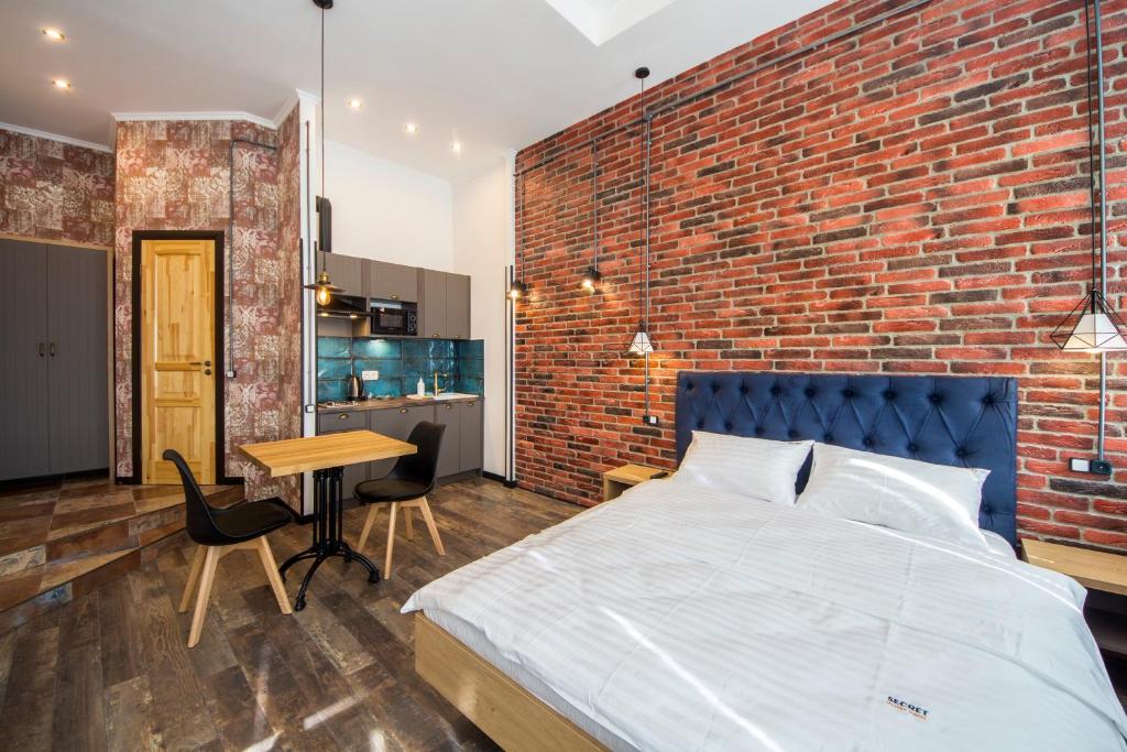 Un dormitorio con una pared de ladrillo y una cama en Secret Apartments en Kiev