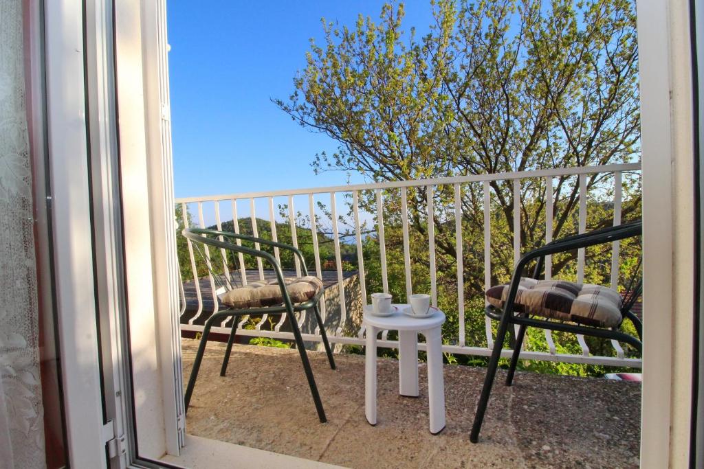 a balcony with two chairs and a table on a balcony at Apartments Felix in Babino Polje