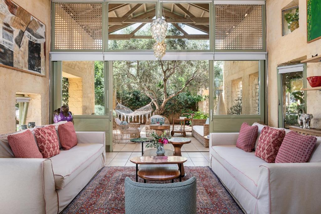 a screened in porch with couches and a table at Villa Dimi in Kalathas