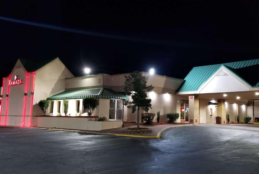 a fast food restaurant with a parking lot at night at Ramada by Wyndham & Suites Warner Robins in Warner Robins