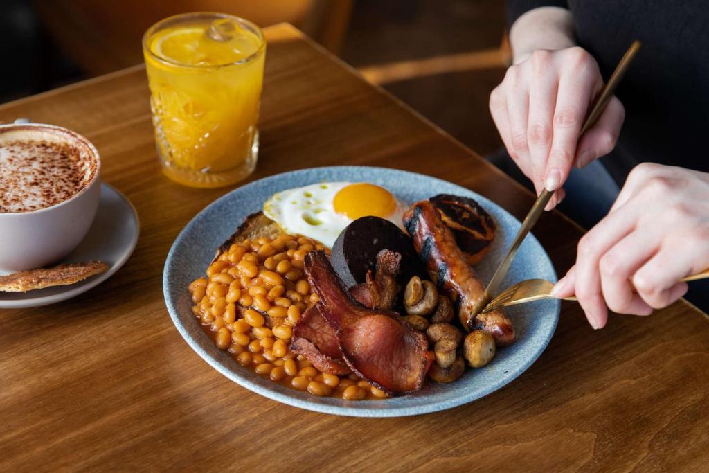 a plate of breakfast food on a wooden table at Dunstan House in Burnham on Sea