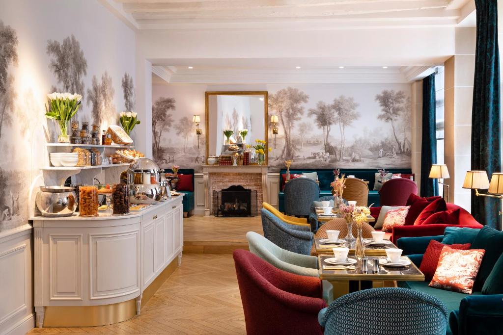 パリにあるOdeon Hotel by Maloneのテーブルと椅子、暖炉のあるレストラン