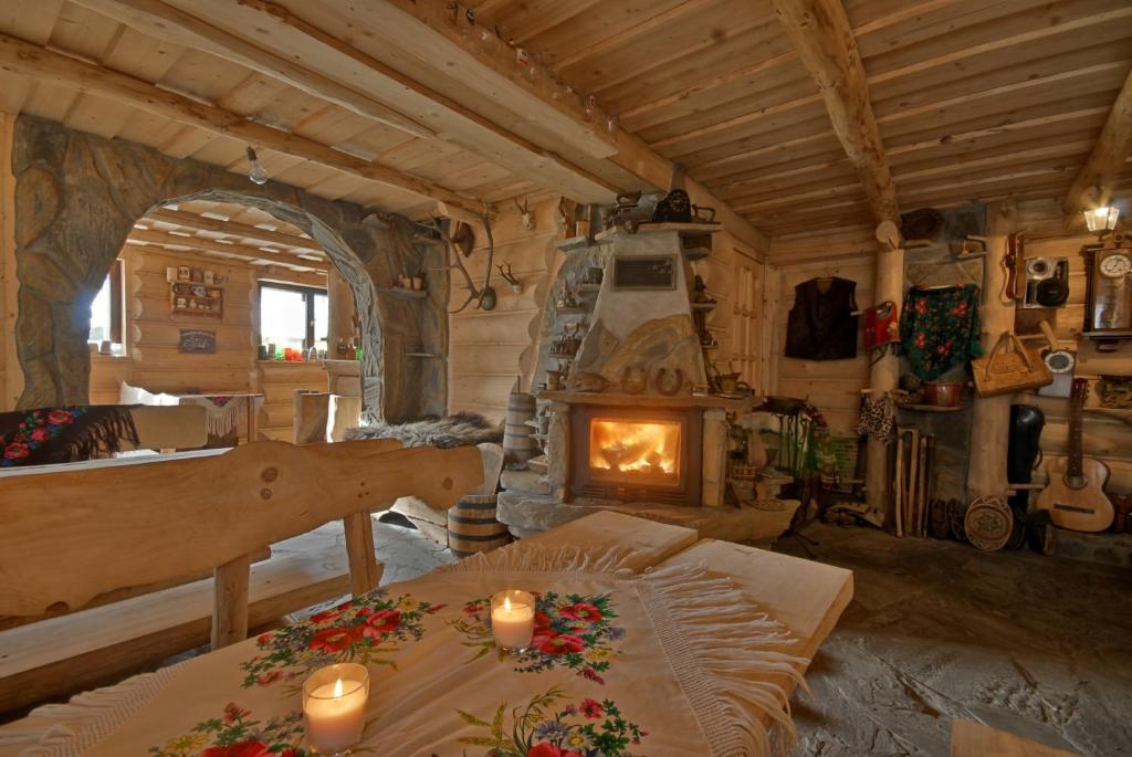Zimmer mit einem Kamin und einem Tisch mit Kerzen in der Unterkunft Dom Gościnny Efka in Kościelisko