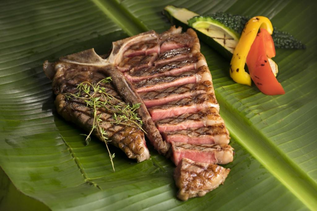 a plate of meat and vegetables on a banana leaf at Sheraton Okinawa Sunmarina Resort in Onna