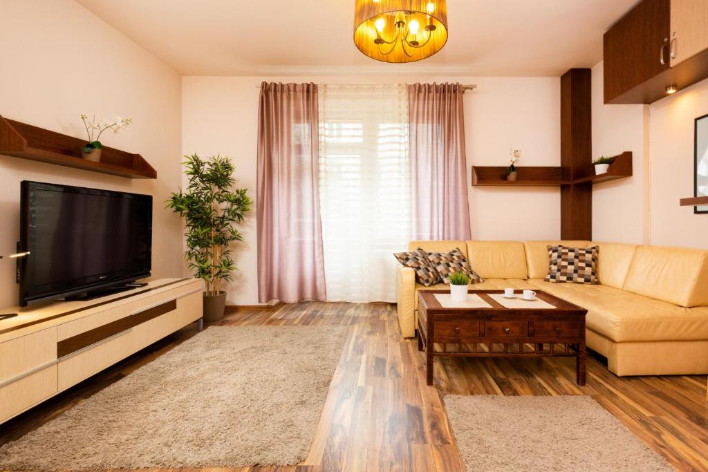 a living room with a couch and a tv at Apartments Warsaw Hoża by Renters in Warsaw
