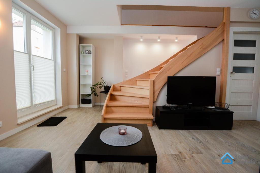 a living room with a staircase and a television at Family house with backyard in Gdynia