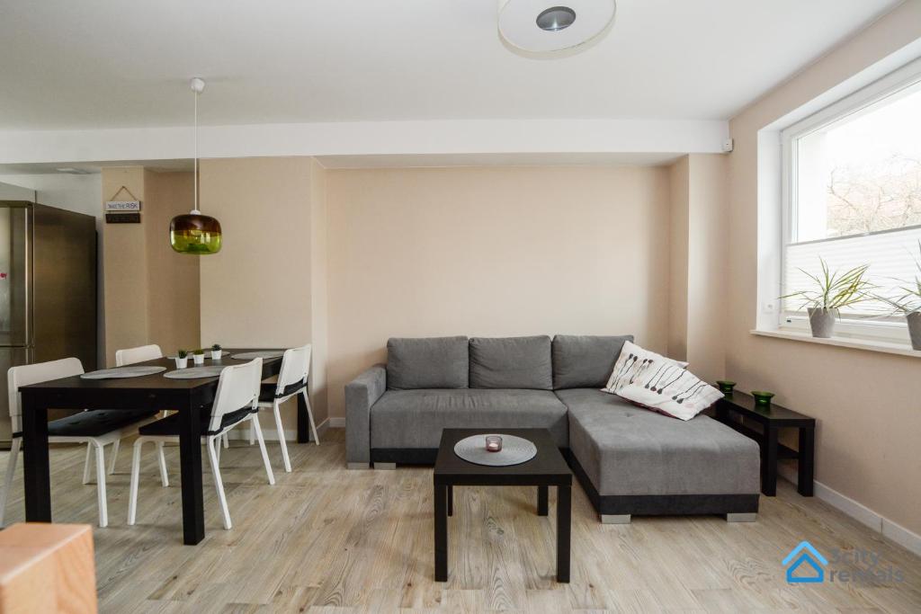a living room with a couch and a table at Dwupoziomowy Apartament 3city w Gdyni z Biurkiem i Balkonem by Noclegi Renters in Gdynia