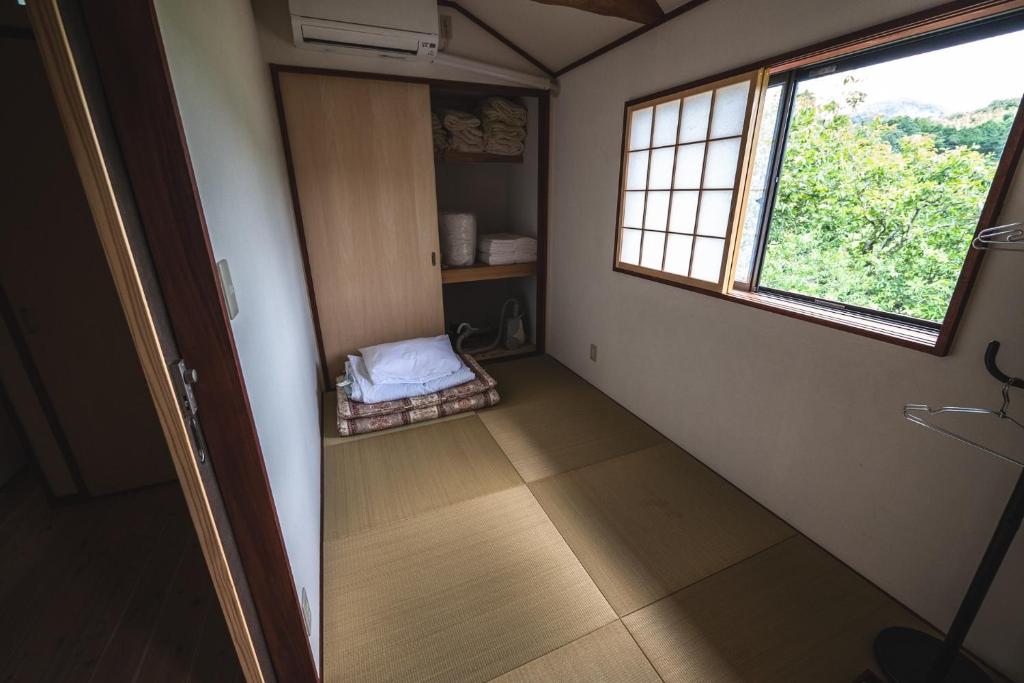 Habitación pequeña con cama y ventana en Guest House Himawari - Vacation STAY 31394 en Mine