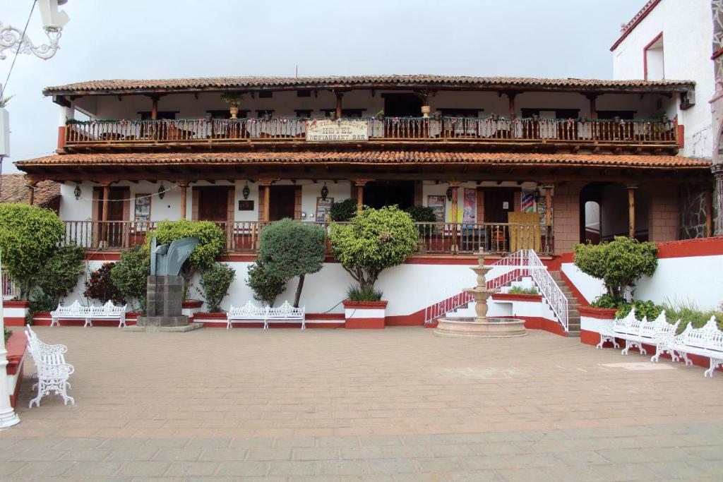 un edificio con sillas blancas delante en La Vieja Casona Hotel, en La Manzanilla