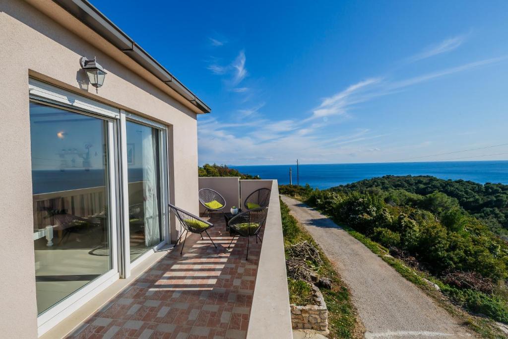 Un balcón con sillas y vistas al océano. en Villa Luana en Vis