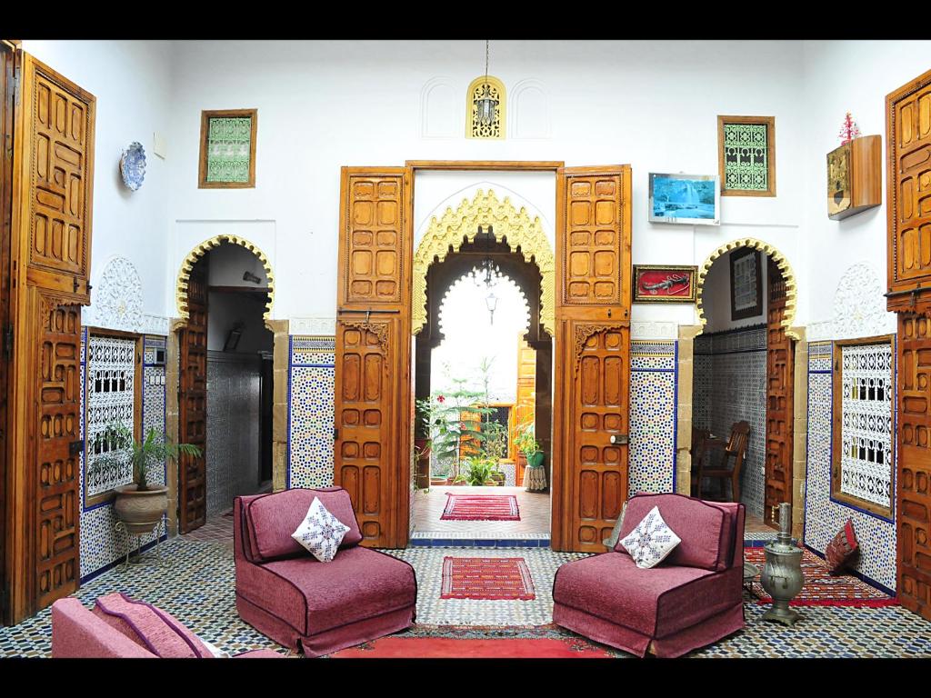 uma entrada para um quarto com duas cadeiras e uma porta aberta em Riad Dar Jabador em Salé