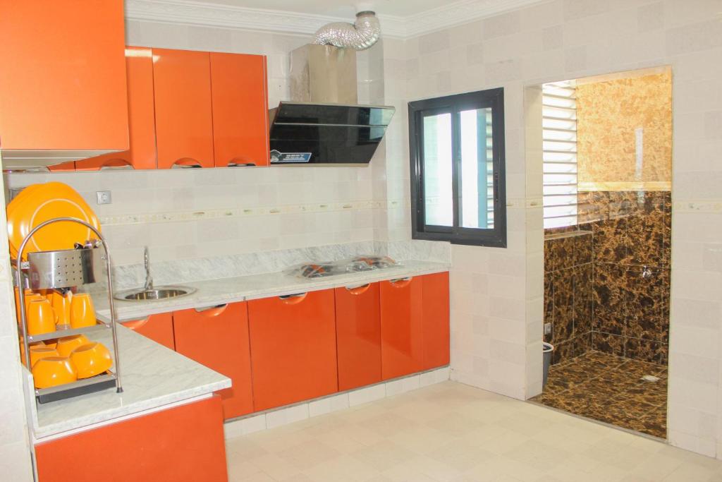 uma cozinha com armários laranja e um chuveiro em IMD Residence em Douala