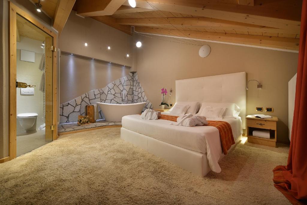 sypialnia z dużym łóżkiem i wanną w obiekcie Hotel Cristallo w Livigno