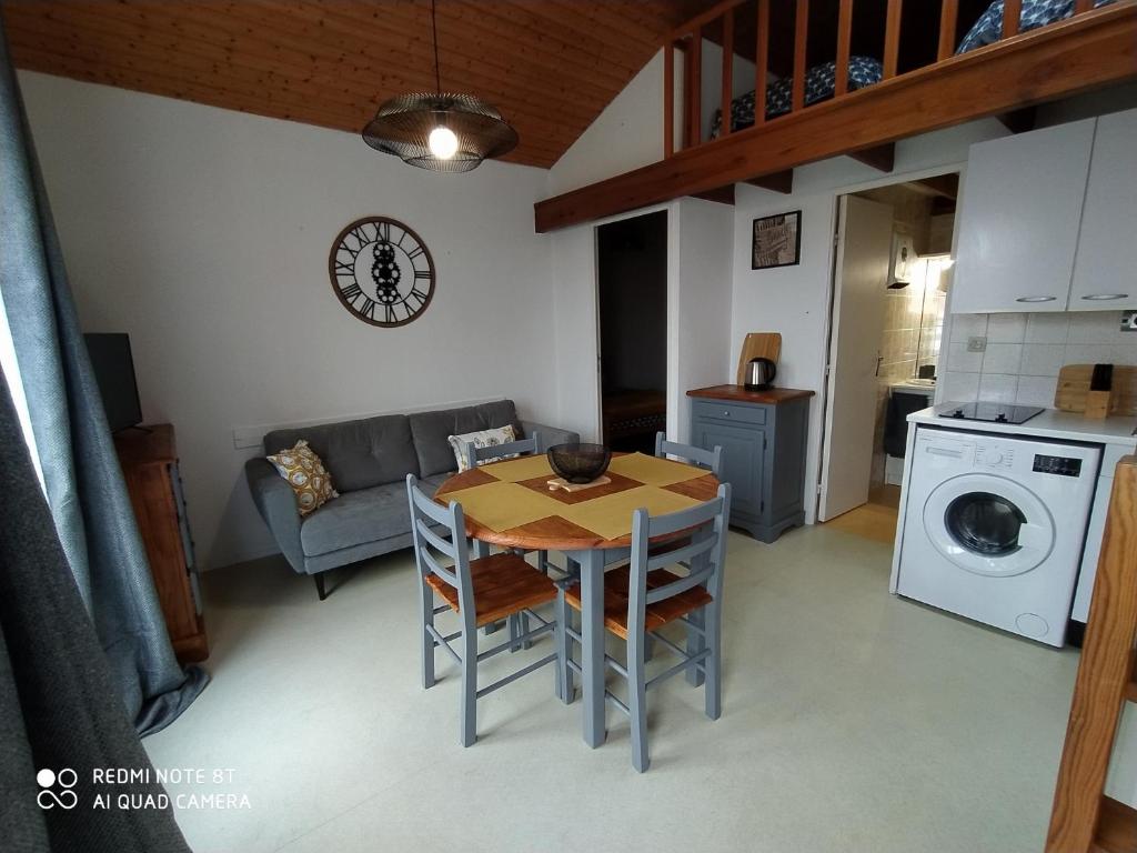 a kitchen and living room with a table and a couch at Logement 88 2-4 Personnes 500 m plage classé 2 étoiles in Dolus d'Oléron