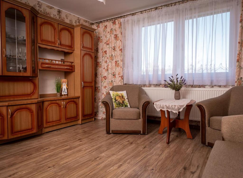 a living room with chairs and a table and a window at Agroturystyka Gawryś apartament in Sasino