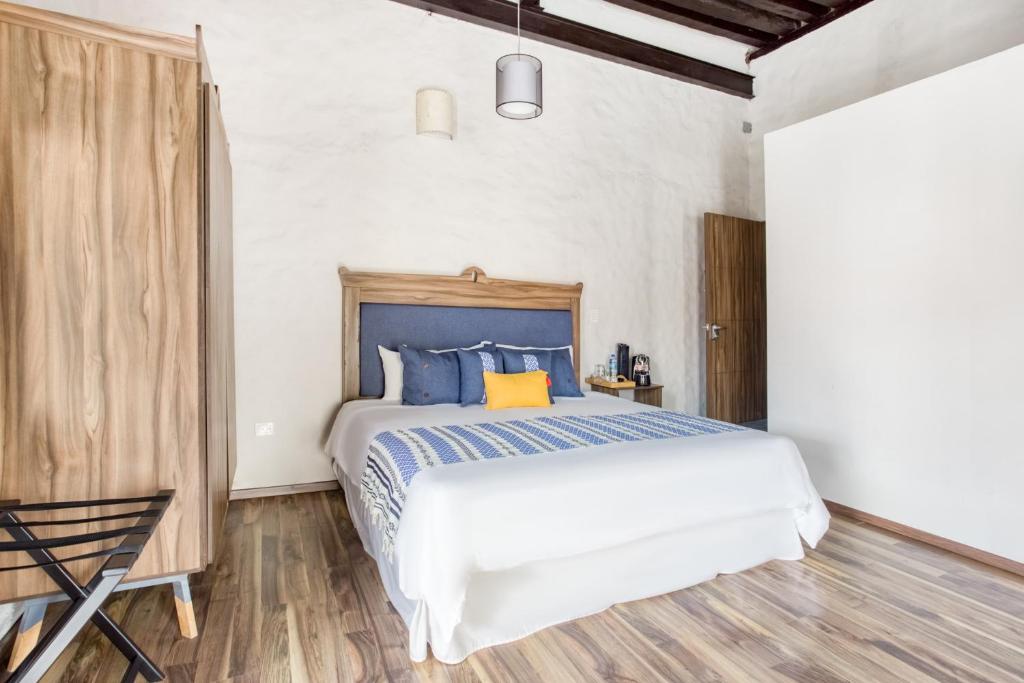 um quarto com uma cama com almofadas azuis e amarelas em Milagro Hotel em Puebla