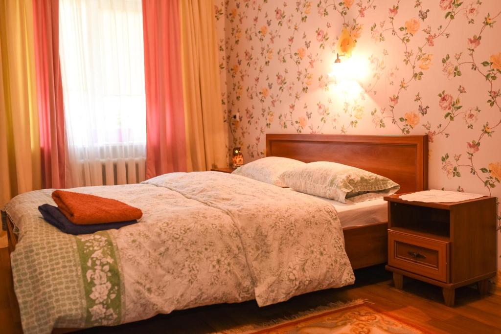 um quarto com uma cama, uma mesa de cabeceira e uma janela em Apartment Horkoho 7A em Shostka
