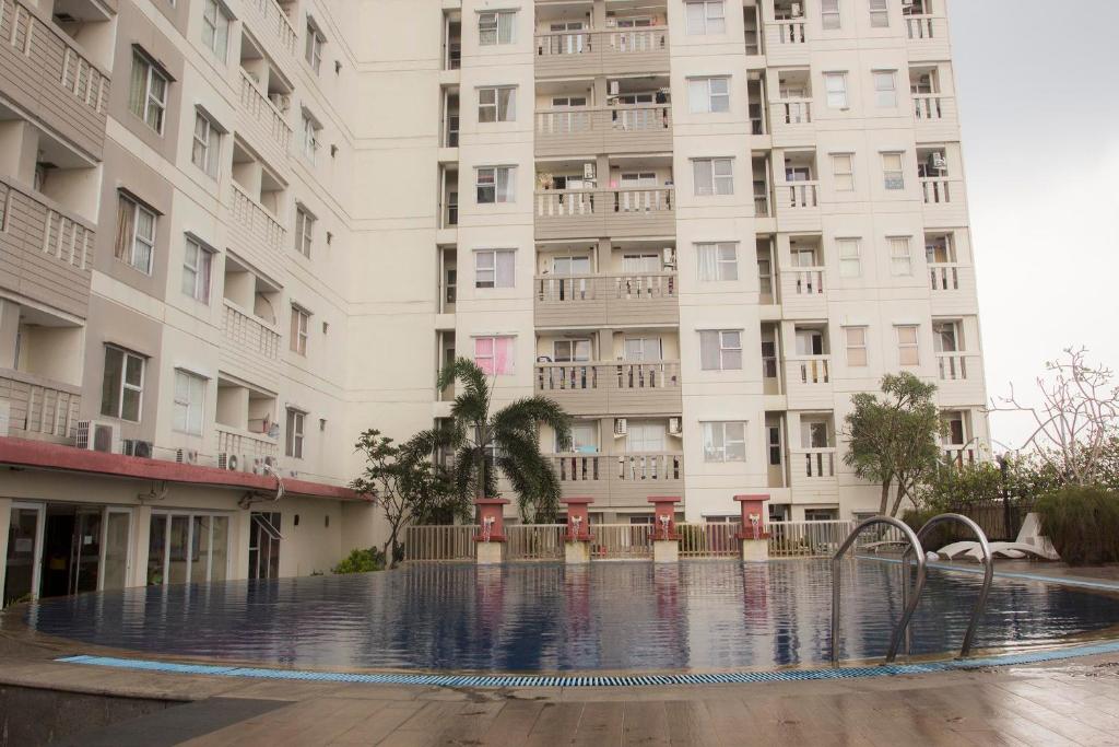 an empty swimming pool in front of a building at DE GREEN INN Kebon Jeruk in Jakarta