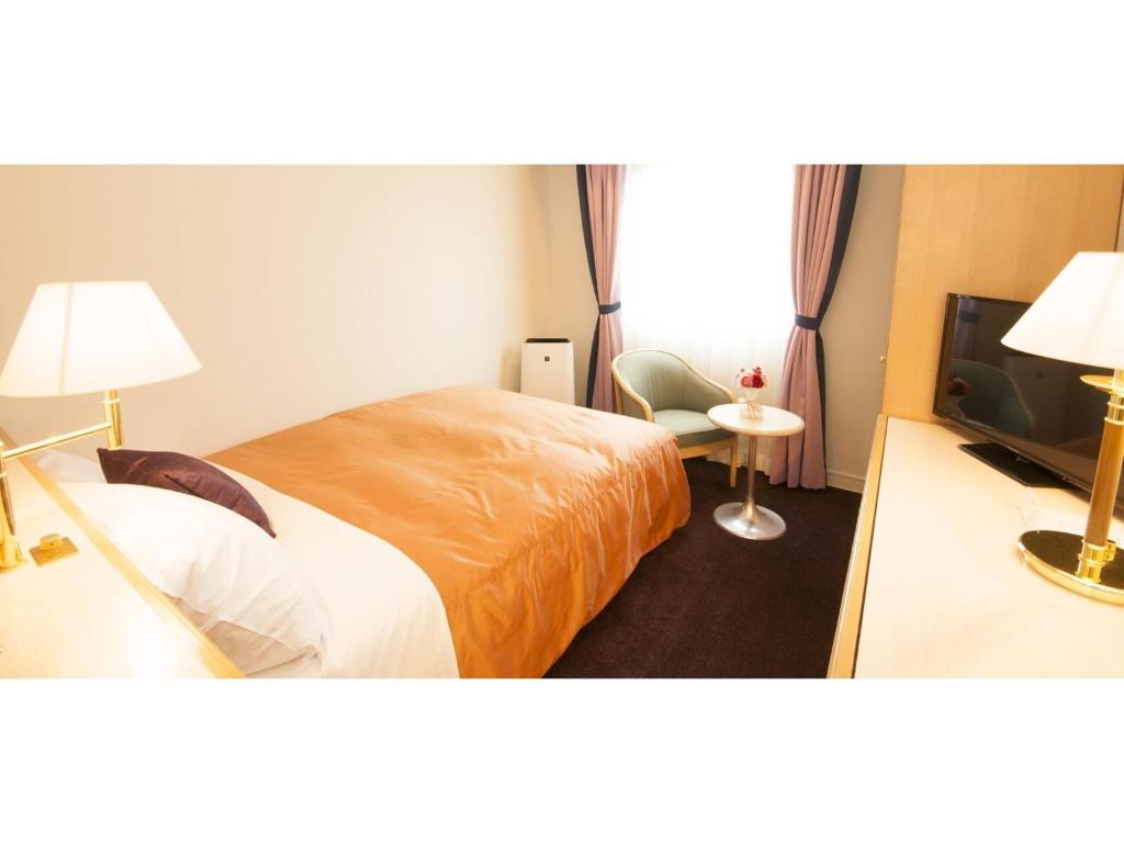 a hotel room with a bed and a television at Grand Park Hotel Panex Hachinohe / Vacation STAY 77754 in Hachinohe