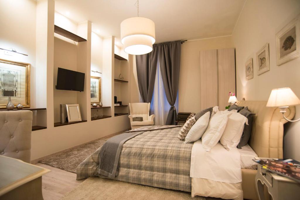 1 dormitorio con 1 cama, 1 silla y TV en Town House 62, en Roma