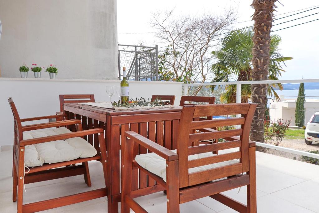 y balcón con mesa y sillas de madera. en Holiday Home Rosemary, en Klek