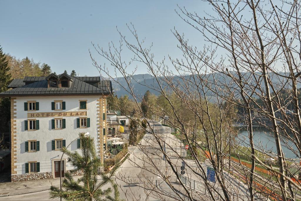 a view of a building with a mountain in the background at Hotel du Lac Parc & Residence in Lavarone