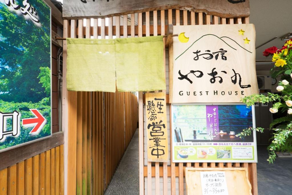 un cartel de la casa de huéspedes en el lateral de un edificio en Oyado Yaokyu 1st Floor in 4 Story Building - Vacation STAY 6713, en Ome
