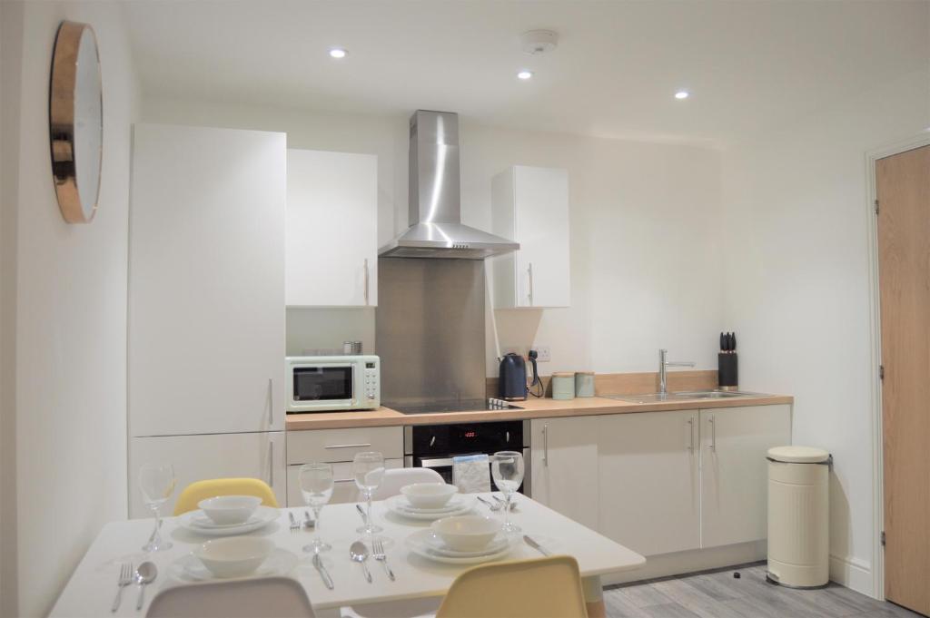 - une cuisine avec une table et des verres à vin dans l'établissement Book our Royal Suite today! Elegant spacious 2 bed apartment in the city centre - perfect for work or leisure!, à Sheffield