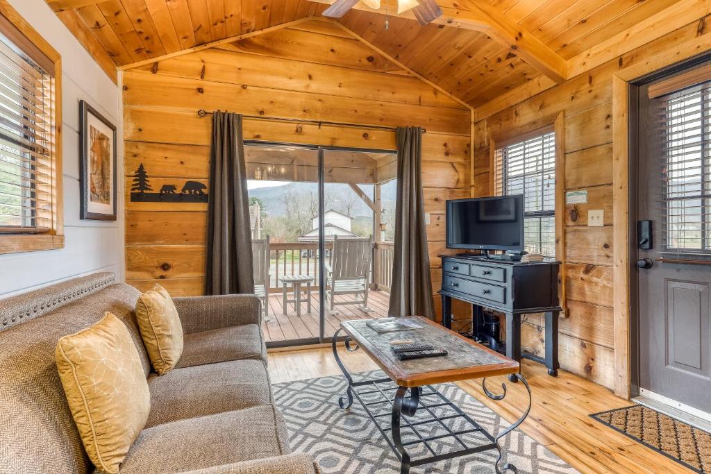 a living room with a couch and a tv at Calvery Cabin in Sevierville