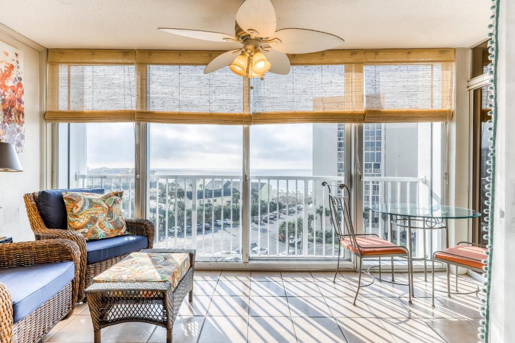 a living room with a ceiling fan and a large window at Shoreline Towers in Destin